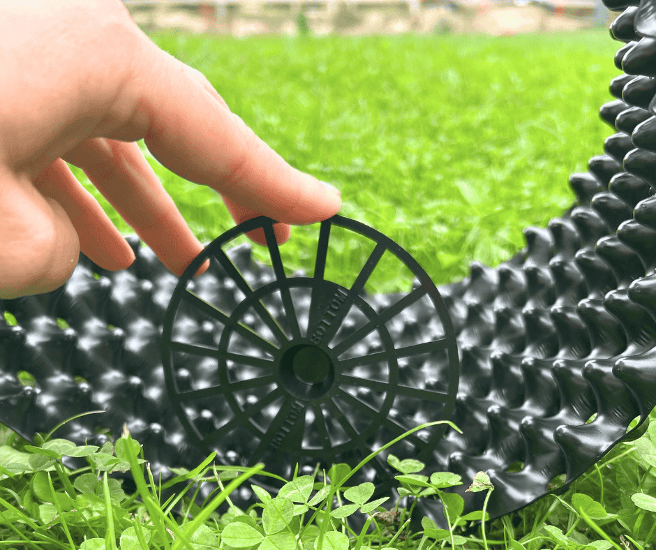 Montáž plastového zahradního dílu na trávníku.